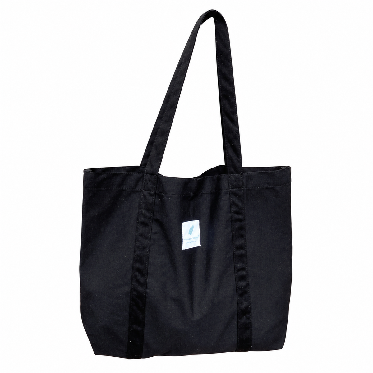 Black canvas tote with long fabric handles and original white sewn label on a white background.